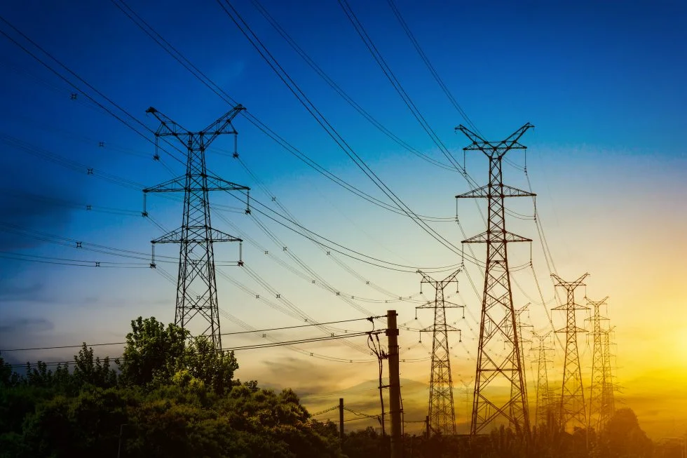 sun setting silhouette electricity pylons min 980x653 1